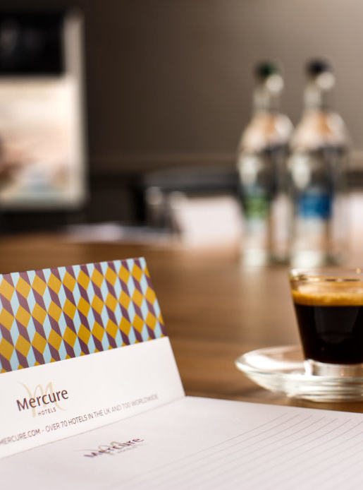 Meeting room table laptop and notepad at mercure hotels