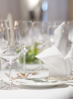 Close up of dinner table decoration with white linen and silverware