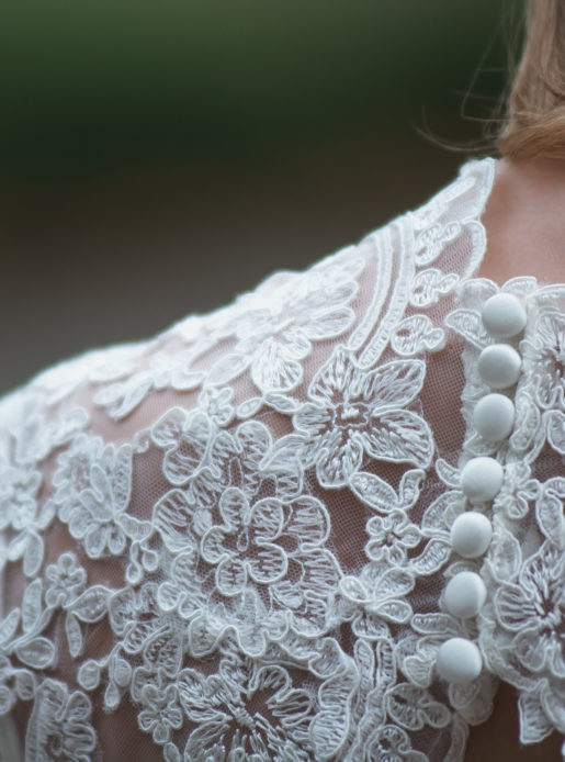 Bride's shoulder and neck, in a white lace dress