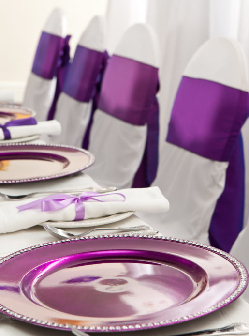 The wedding breakfast top table in the Central Avenue Suite at Mercure Bolton Georgian House Hotel, white linen, purple sashes and plates